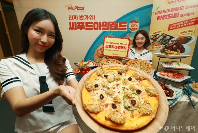 26일 오전 서울 중구 미스터피자 청계광장점에서 열린 여름 신메뉴 '씨푸드아일랜드' 피자 출시 기념행사에서 모델들이 신제품을 선보이고 있다. 씨푸드아일랜드는 코코넛 쉬림프를 비롯해 솔방울 오징어, 버터플라이 쉬림프 등 해산물을 담아 풍성한 바다의 풍미를 담은 프리미엄 피자다. / 사진=이동훈 기자 photoguy@