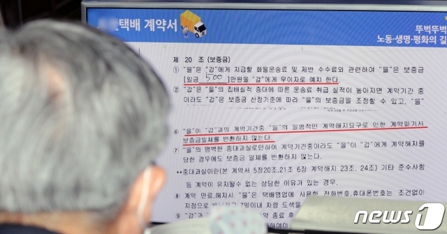 이재갑 고용노동부 장관이 26일 정부세종청사에서 열린 국회 환경노동위원회의 고용노동부, 경제사회노동위원회, 중앙노동위원회 등 소관기관에 대한 국정감사에서 윤미향 더불어민주당이 공개한 한 택배사의 계약서를 바라보고 있다/사진=뉴스1