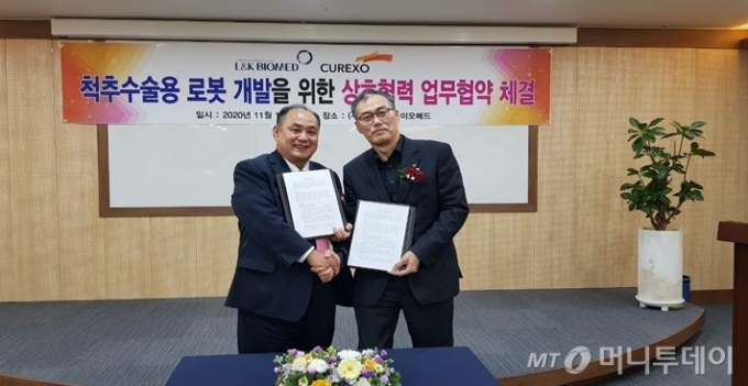 왼쪽부터) 박근주 엘앤케이바이오메드 대표이사와 이재준 큐렉소 대표이사가 기념촬영하고 있다/사진제공=엘앤케아바이오메드