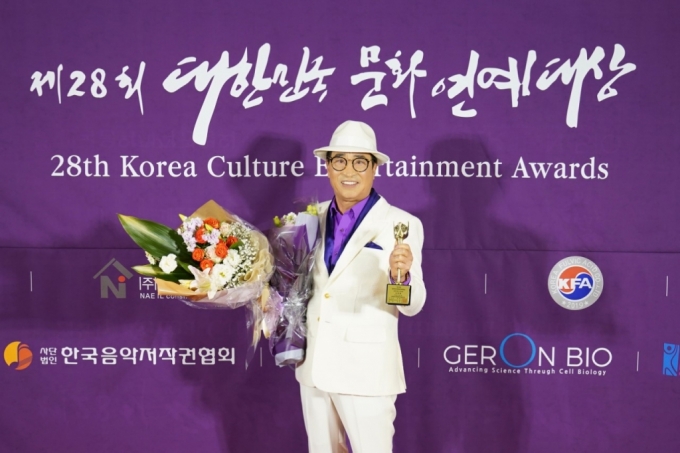 김명환 덕신하우징 회장이 지난 27일 강남 더리버사이드호텔에서 개최된 '제 28회 대한민국 문화연예대상'에서 성인가요부문 신인상을 수상한 후 기념 사진 촬영을 하고 있다./사진제공=덕신하우징