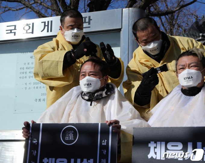 (서울=뉴스1) 신웅수 기자 = 16일 오후 서울 여의도 국회 앞에서 헬스클럽관장연합회 소속 회원들이 생존권 보장을 촉구하며 삭발을 하고 있다. 헬스장 등 실내체육시설은 수도권 사회적 거리두기 2.5단계 격상에 따라 집합금지 명령이 내려졌다.(헬스클럽관장연합회 제공) 2020.12.16/뉴스1