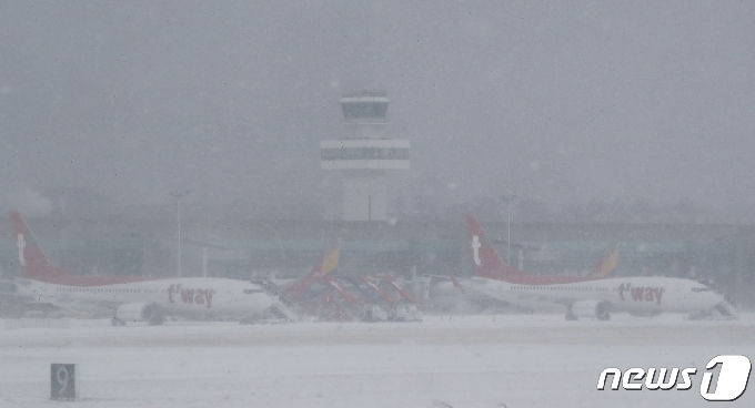 8일 오전 급변풍·강풍·대설특보가 발효 중인 제주국제공항 계류장에 항공기들이 멈춰서 있다. 제주지방기상청에 따르면 이날 오전 7시30분 현재 제주도 산지에는 한파경보, 제주도 산지·동부·북부에는 대설경보, 제주도 서부·남부·추자도에는 대설주의보가 발효 중이다.2021.1.8 /뉴스1 © News1 오현지 기자
