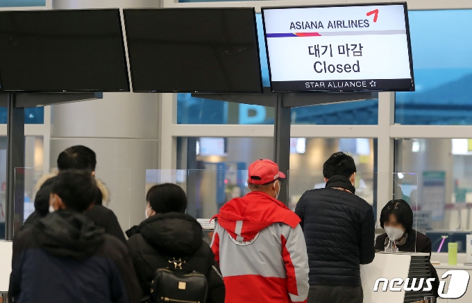 8일 오전 급변풍· 강풍·대설특보 발효로 결항이 속출하고 있는 제주국제공항에서 이용객들이 항공사 안내 카운터에서 대기하고 있다.2021.1.8 /뉴스1 © News1 오현지 기자
