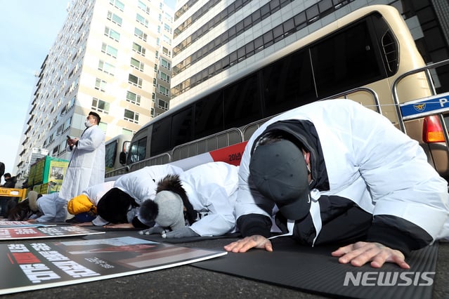 필라테스 피트니스 사업자연맹 관계자들이 이달 12일 서울 여의도 더불어민주당 당사 앞에서 열린 기자회견에서 고위험시설 해제를 촉구하며 소복을 입고 절하는 퍼포먼스를 하고 있다. / 사진제공=뉴시스