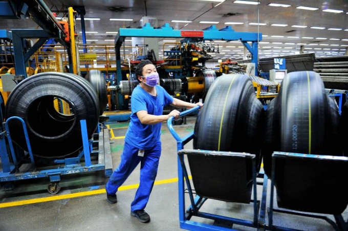 [칭다오=AP/뉴시스] 24일(현지시간) 중국 산둥성 칭다오시에 위치한 공장에서 마스크를 낀 노동자가 제조된 타이어를 옮기고 있다. 2020.02.28.