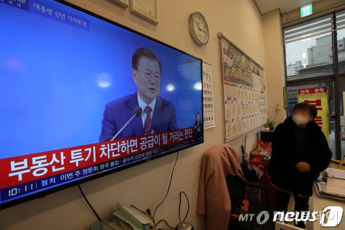 (서울=뉴스1) 이승배 기자 = 18일 오전 서울 시내의 한 공인중개사 사무소에서 부동산 업자가 문재인 대통령 신년 기자회견 생중계 방송을 지켜보고 있다. 청와대 춘추관에서 열린 이번 기자회견은 사회적 거리두기를 고려해 문재인 대통령 취임 후 처음으로 온·오프라인 화상 연결 방식으로 개최됐다. 2021.1.18/뉴스1