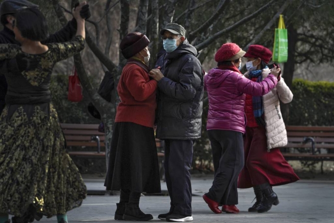 [베이징=AP/뉴시스]12일 중국 베이징의 한 공원에서 코로나19 예방을 위해 마스크를 쓴 사람들이 사교춤을 즐기고 있다. 2021.01.12.