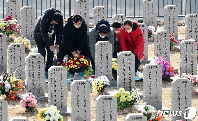 지난달 31일 대전 유성구 국립대전현충원 묘역에서 가족 단위 참배객들이 설날을 앞두고 미리 참배하고 있다. 2021.1.31/뉴스1 &copy; News1 김기태 기자