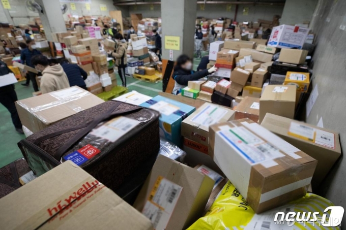 (서울=뉴스1) 이재명 기자 = 민족 대명절 설을 앞둔 9일 오전 서울 송파우체국에서 집배원 등 직원들이 택배를 분류하고 있다. 2021.2.9/뉴스1