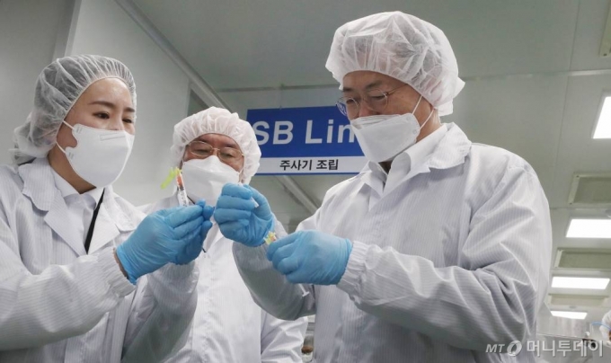 문재인 대통령이 18일 오후 전북 군산시 코로나19 백신접종용 최소잔여형(LDS) 백신주사기 생산 현장인 풍림파마텍을 방문해 일반 주사기와 LDS 백신주사기 비교 시연을 하고 있다. /사진=뉴시스
