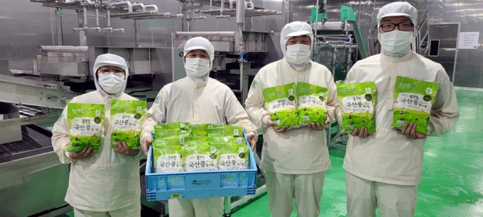 발달장애인 근로자들이 화재 후 새롭게 준공한 강화도 우리마을 콩나물 공장에서 생산한 풀무원 국산콩 무농약 콩나물을 들어 보이고 있다. /사진= 풀무원