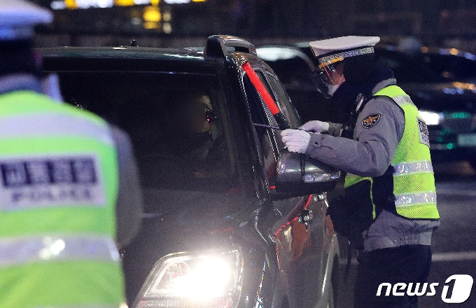 음식점 영업종료 시간에 맞춰 음주단속에 나선 강남경찰서 경찰관이 23일 오후 서울 신사역사거리에서 음주운전 차량에 비접촉식 감지기를 넣자 감자지가 빨갛게 표시되고 있다. 2021.2.23/뉴스1 © News1 박지혜 기자