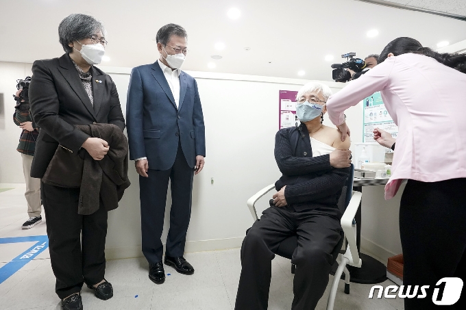 문재인 대통령이 신종 코로나 바이러스 감염증(코로나19) 백신 접종이 시작된 26일 오전 서울 마포구보건소를 방문해 김윤태 푸르메재단 넥슨어린이재활병원장이 접종 받는 모습을 지켜보고 있다. 왼쪽은 정은경 질병관리청장. 2021.2.26/뉴스1 © News1 이광호 기자