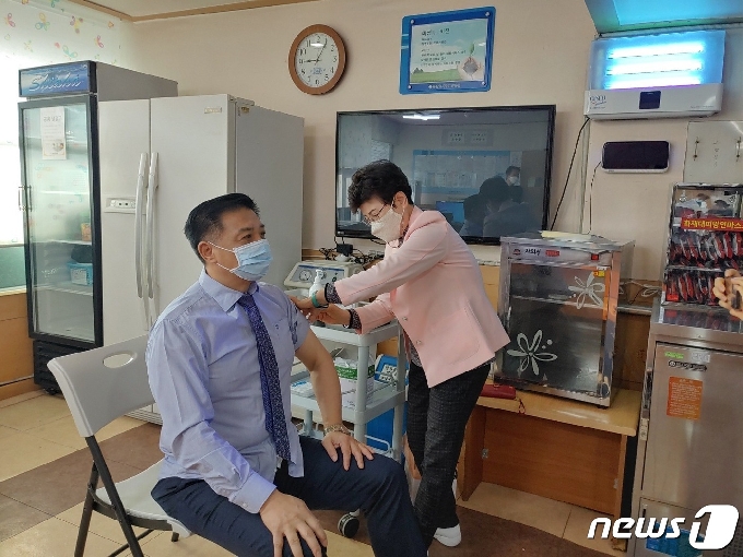 배용정 금산효사랑이사장이 금산 첫번째 접종자로 코로나19 예방 백신을 맞고 있다.(금산군 제공)© 뉴스1