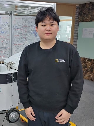 이상민 뉴빌리티 대표가 현재 개발 중인 카메라 기반 자율주행 배달로봇 앞에서 포즈를 취하고 있다/사진=류준영 기자