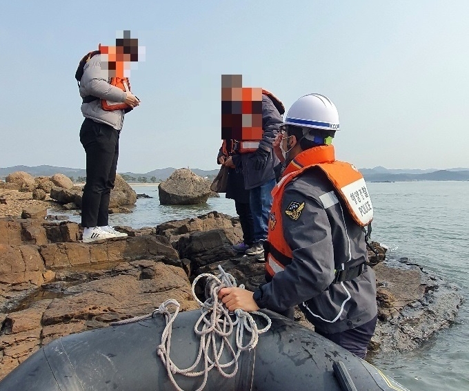 한 가족 3명이 보령시 천북면 인근 갯바위에 고립됐다가 해경에 의해 구조되고 있다.&#40;보령해경 제공&#41;&copy; 뉴스1