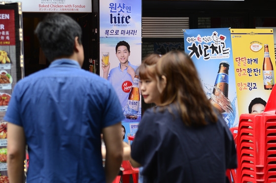 = 관광객들이 28일 서울 중구 명동 술을 선전하는 광고판 앞에서 얘기를 나누고 있다. 기획재정부와 국세청 등은 지난해 주세가 총 3조2,275억원으로 전년보다 13.2% 증가했고 역대 처음으로 3조원을 넘어섰다고 밝혔다. 최근 식품의약품안전처가 발표한 상반기 주류 소비·섭취 실태에 따르면 한국인의 1회 평균 음주량은 맥주의 경우 4.9잔(200㎖ 기준) 소주는 6.1잔인 것으로 나타났다. 식약처는 “남성은 세계보건기구(WHO)가 제시한 적정량보다 소주를 많이 마시고 있었으며 여성은 모든 주종에서 WHO 기준보다 더 많이 마셨다”고 덧붙였다. 2016.8.28/뉴스1  