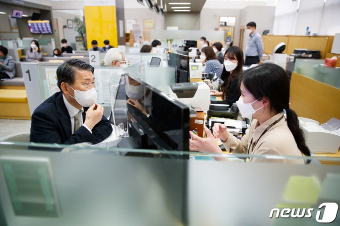 (서울=뉴스1) = 은성수 금융위원장이 26일 서울 종로구 KB국민은행 광화문종합금융센터를 방문해 은행직원에게 금융소비자보호법 관련 현황을 듣고 있다. (금융위원회 제공) 2021.3.26/뉴스1