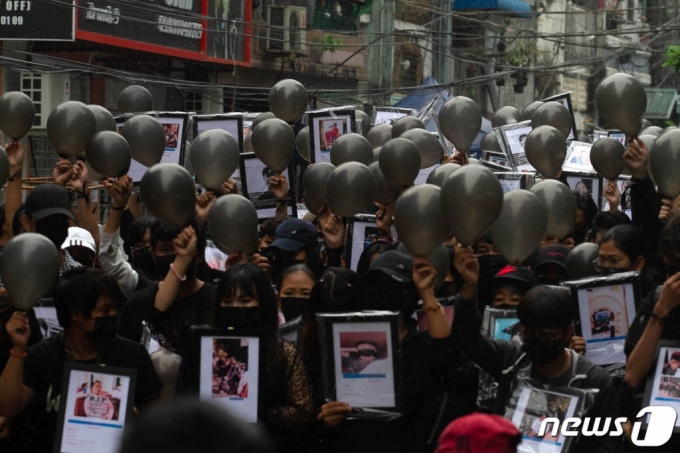 (양곤 AFP=뉴스1) 우동명 기자 = 5일(현지시간) 미얀마 양곤에서 군부 쿠데타를 규탄하는 시위대가 시위 중 숨진 시민의 사진과 가면을 들고 시위를 하고 있다. (C) AFP=뉴스1