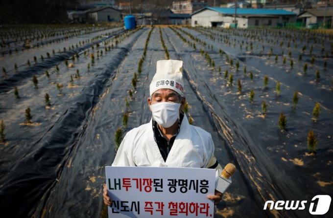 (시흥=뉴스1) 안은나 기자 = 10일 한국토지주택공사(LH) 직원들이 사들인 경기 시흥 과림동 소재 농지에서 공공주택지구 전국연대대책협의회(공전협) 긴급 기자회견을 마친 한 참가자가 상복을 입은 채 신도시 철회를 촉구하고 있다. 공전협은 LH 직원들의 3기 신도시 토지 투기를 규탄하며 신도시 백지화와 공공주택특별법 폐지를 촉구했다. 2021.3.10/뉴스1