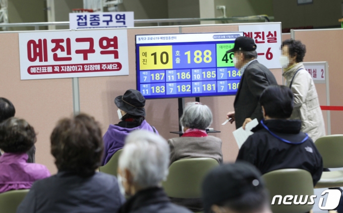 (서울=뉴스1) = 주말인 17일 오전 서울 동작구 사당종합체육관에 마련된 코로나19 접종센터에서 어르신들이 앉아 있다가 번호 순번에 따라 화이자 백신 접종 예진실로 들어가고 있다. (동작구 제공) 2021.4.17/뉴스1