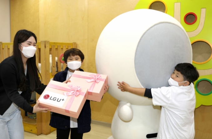 4일 한국백혈병소아암협회를 방문한 홀맨과 LG유플러스 임직원이 소아암 환아에게 선물을 전달하고 있다. /사진=LG유플러스