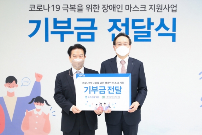 우리금융그룹은 4일 서울시 중구 소재 우리은행 본점에서 ‘코로나19 극복을 위한 장애인 마스크 지원사업’ 기부금 전달식을 열었다. 손태승(오른쪽) 우리금융그룹 회장과 최공열(왼쪽) 한국장애인단체총연맹 상임대표가 기념촬영을 하고 있다/사진=우리금융 제공