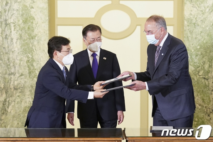 22일 오전(현지시간) 워싱턴 한 호텔에서 열린 '한미 백신 기업 파트너십 행사'에서 문재인 대통령이 참석한 가운데 백신 연구 개발 협력 MOU가 진행되고 있다. 왼쪽부터 권덕철 보건복지부 장관, 문 대통령, 스탠리 어크 노바백스 CEO. (청와대 제공) 2021.5.23/뉴스1