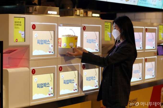CJ CGV가 대면 서비스를 최소화한 '언택트시네마'를 선보인 가운데 21일 서울 CGV 여의도에서 한 시민이 직원과 대면 없는 '픽업박스'를 이용해 팝콘을 구매하고 있다. '언택트시네마'는 다양한 하이테크 기술을 통해 언택트(Un-tact) 서비스를 기반으로 새롭고 간편하게 극장 시설을 이용할 수 있는 서비스다. /사진=이기범 기자 leekb@