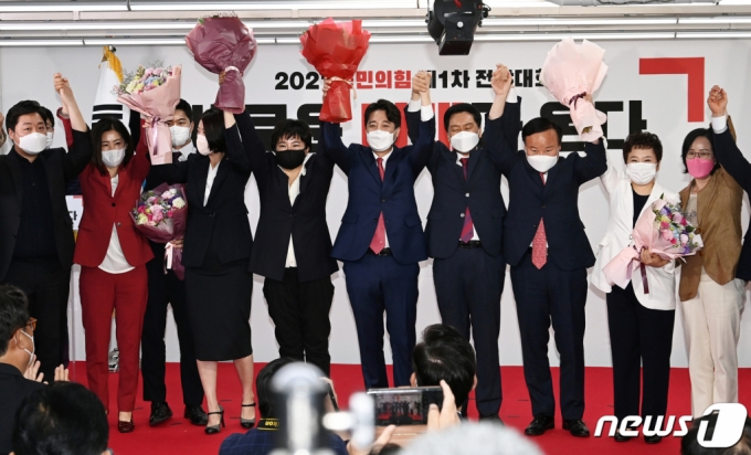 이준석 국민의힘 신임 대표(가운데)가 11일 오전 서울 영등포구 국민의힘 당사에서 열린 전당대회에서 신임 최고위원들과 함께 꽃다발을 들고 인사하고 있다. '30대·0선'의 이 대표는 역대급 전당대회 흥행을 주도한 끝에 헌정사상 최초의 30대 보수정당 대표에 올랐다. /사진=뉴스1