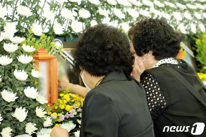 11일 오전 광주 붕괴 사고 희생자들의 합동분향소가 차려진 광주 동구청 앞 분향소에서 희생자 친구들이 영정사진을 만지며 오열하고 있다.2021.6.11/뉴스1 © News1 허단비 기자