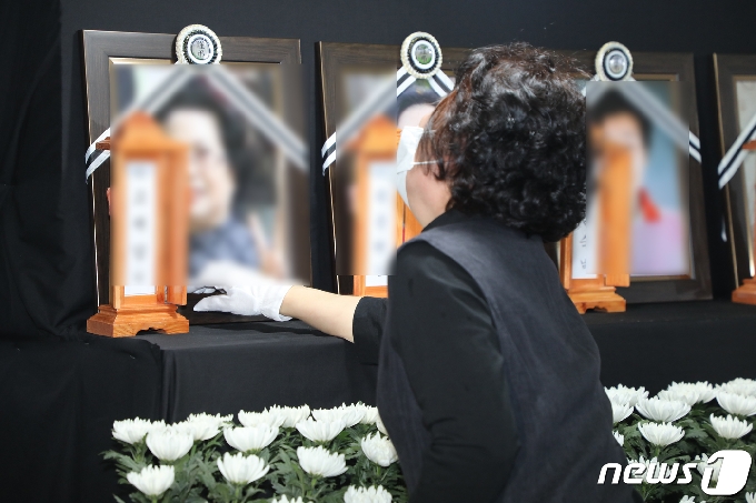 10일 오후 광주 건물 붕괴 참사 희생자들의 합동분향소가 차려진 광주 동구청 앞에서 한 유가족이 희생자 영정사진을 만지며 오열하고 있다.2021.6.10/뉴스1 © News1 허단비 기자