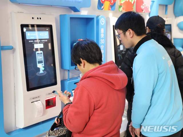알리바바가 운영하는 허마셴셩에서 고객들이 스마트폰으로 상품 진열대 곳곳에 붙어있는 QR코드를 찍어 장을 보고 있다./사진=뉴시스 