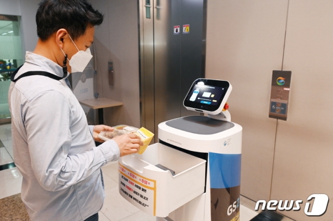 LG전자는 올 5월 서울 강남구 역삼동 GS타워 1층에 있는 GS25 편의점에서 &#039;LG 클로이 서브봇&#039;(LG CLOi ServeBot)을 이용해 건물 내 고객들에게 상품을 배송하는 로봇 배달 서비스를 시작했다.  &#039;LG 클로이 서브봇&#039;은 GS타워 내에서 스스로 엘리베이터를 타고 층간을 오가며 입주 고객들에게 도시락, 샌드위치, 음료 등을 배달한다. LG 클로이 서브봇이 고객에게 편의점 주문 물건을 전달하고 있다. /사진제공=LG전자 제공