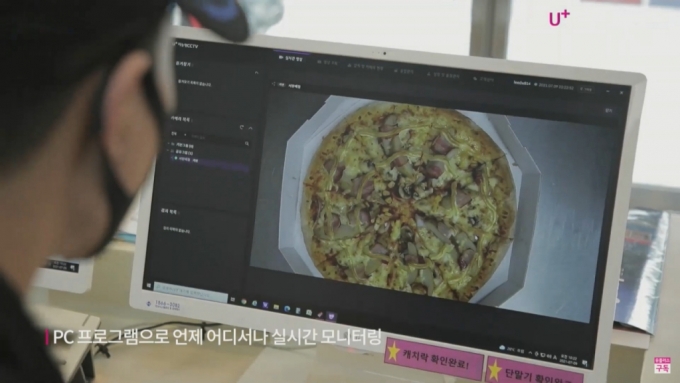 도미노피자 매장에서 '매장안심형 CCTV'로 피자 제조 상황을 모니터링 하는 모습. /사진=LG유플러스