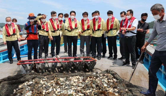 ▲문성혁 해양수산부 장관과 김영록 전남지사, 이승옥 강진군수 등이 12일 오후 집중호우로 피해를 입은 강진군 마량해역 전복가두리 양식장을 찾아 폐사된 전복을 살펴보고 있다./사진=전남도 제공