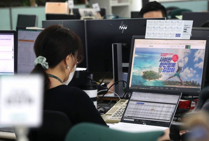 지난 1일 서울 중구 모두투어 본사에서 직원들이 곧 재개될 사이판 여행 상품을 보며 단체여행 예약 목록을 확인하고 있다. /사진=뉴시스