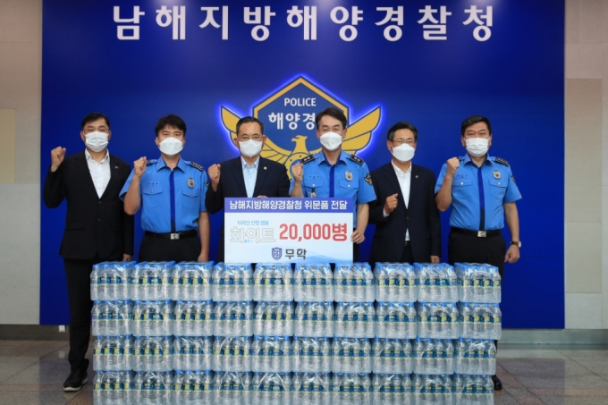 이수능 무학 사장(왼쪽에서 세 번째)이 22일 서승진 남해지방해양경찰청장(왼쪽에서 네 번째)에게 생수를 전달하고 있다./사진제공=무학
