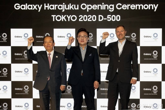 2019년 3월12일 일본 도쿄에서 열린 '갤럭시 하라주쿠' 개관식에 참석한 (왼쪽부터) 무토 토시로 2020 도쿄올림픽 조직위원회 사무총장, 고동진 삼성전자 IM부문장 사장, 티모 루베 국제올림픽위원회 마케팅국장이 2020 도쿄올림픽의 성공적인 개최를 기원하며 기념사진을 촬영하고 있다.