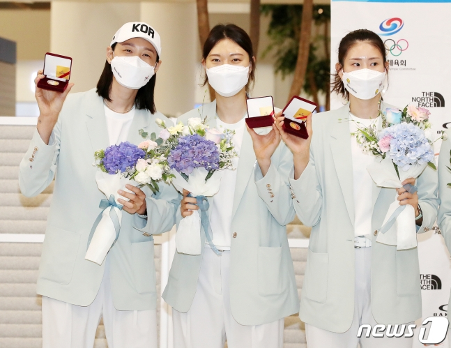 여자 배구대표팀 김연경, 양효진, 김수지(왼쪽부터)가 지난 9일 인천국제공항 제2터미널에서 열린 2020 도쿄올림픽 대한민국 선수단 환영 행사에서 배구협회가 제작한 기념주화를 들어보이고 있다./사진=뉴스1