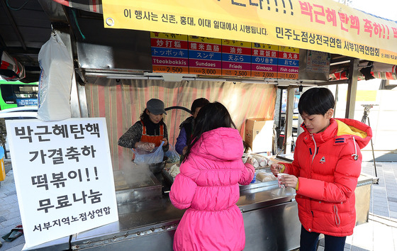 = 10일 오후 서울 서대문구 신촌역에서 노점상인이 시민들에게 '박근혜 대통령 탄핵 축하 떡볶이 무료나눔' 행사를 하고 있다. 민주노점상전국연합 서부지역연합회는 신촌, 홍대, 이대 등에서 박근혜 탄핵안 가결을 기념해 떡볶이를 시민들에게 무료로 나누는 행사를 갖는다고 밝혔다. 2016.12.10/뉴스1  