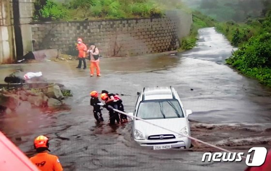 제14호 태풍 '찬투'(CHANTHU)의 영향으로 지난 14일 오전 제주시 용강동 한 도로에 물이 불어나 차량에 고립됐던 한 시민이 119구조대에 의해 구조되고 있다./사진=뉴스1(제주소방서 제공)