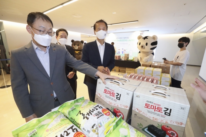 구현모 KT 대표이사(왼쪽)와 최문순 강원도지사(오른쪽)가 지난 14일 서울 종로구에 위치한 광화문 KT 이스트사옥에서 강원도 지역 특산물을 보고 있다./사진제공=KT