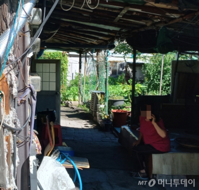 지난 13일 서울 종로구 창신동의 쓰레기촌 거주민 최모씨(73)가 그늘에 앉아 쉬고 있다./사진=양윤우 기자 