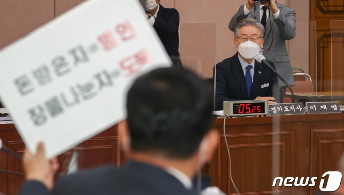 이재명 경기도지사가 20일 경기도 수원시 팔달구 경기도청에서 열린 국회 국토교통위원회의 경기도에 대한 국정감사에서 대장동 관련 피켓을 든 박정민 국민의힘 의원을 바라보고 있다. /사진=뉴스1