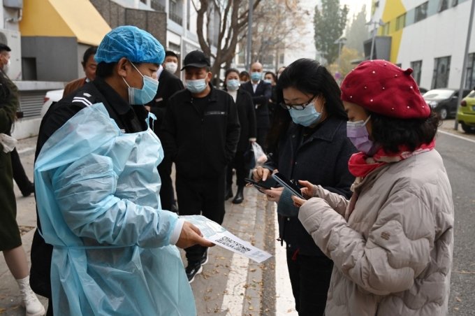 중국 베이징에서 방역당국 관계자가 시민들의 코로나 확진 여부를 체크하고 있다. /사진=AFP