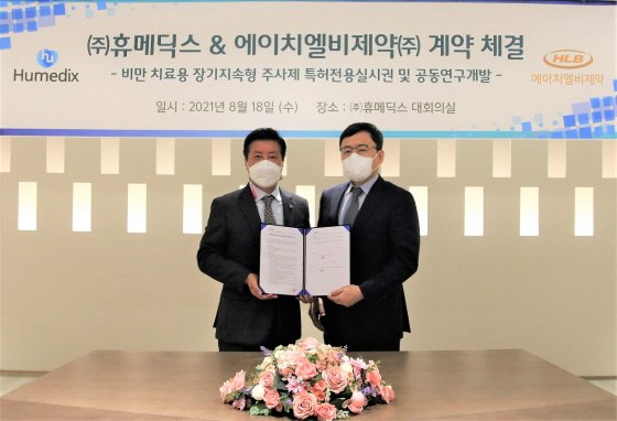 지난 8월 18일 김진환 휴메딕스 대표(왼쪽)와 전복환 에이치엘비제약  대표(오른쪽)가 '비만치료 장기지속형주사제 공동연구개발 계약'을 체결하고 기념촬영을 하고있다./사진제공=휴온스
