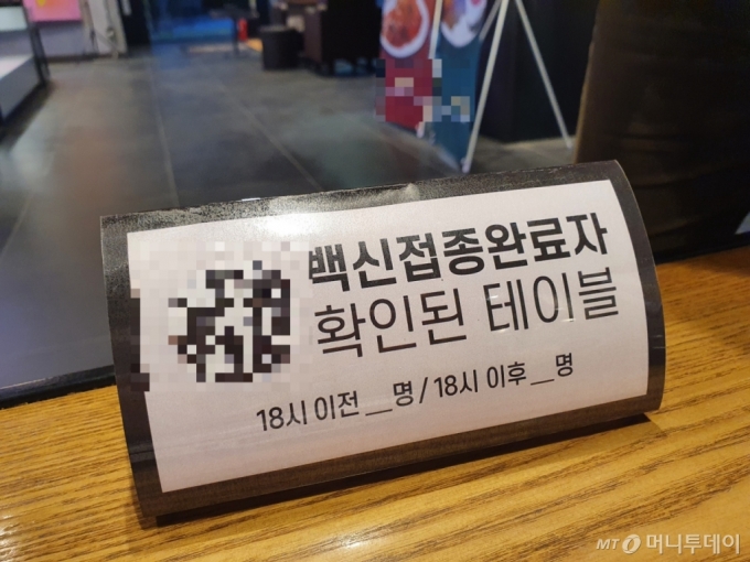 13일 서울 광진구의 한 카페에 &#039;백신 접종을 완료했다&#039;는 내용의 팻말이 놓여 있다. / 사진 = 오진영 기자 