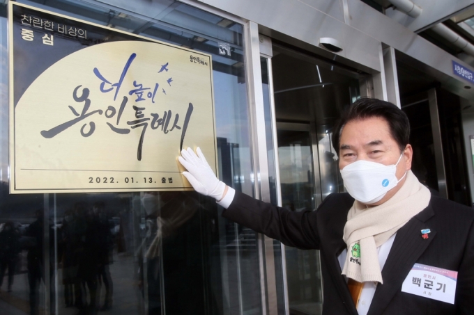 사진=백군기 용인시장이 3일 용인시청사 입구에 용인특례시 현판을 걸고 미소짓고 있다./사진제공=용인시