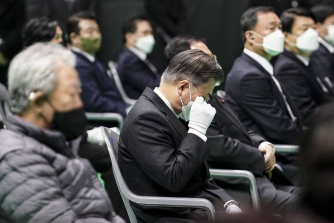 [평택=뉴시스] 문재인 대통령이 8일 오전 경기도 평택시 이충문화체육센터에서 엄수된 경기도 순직 소방공무원 영결식에서 고인의 동료 소방관의 조사를 듣던 중 눈물을 닦고 있다. (사진=청와대 제공) 2022.01.08.